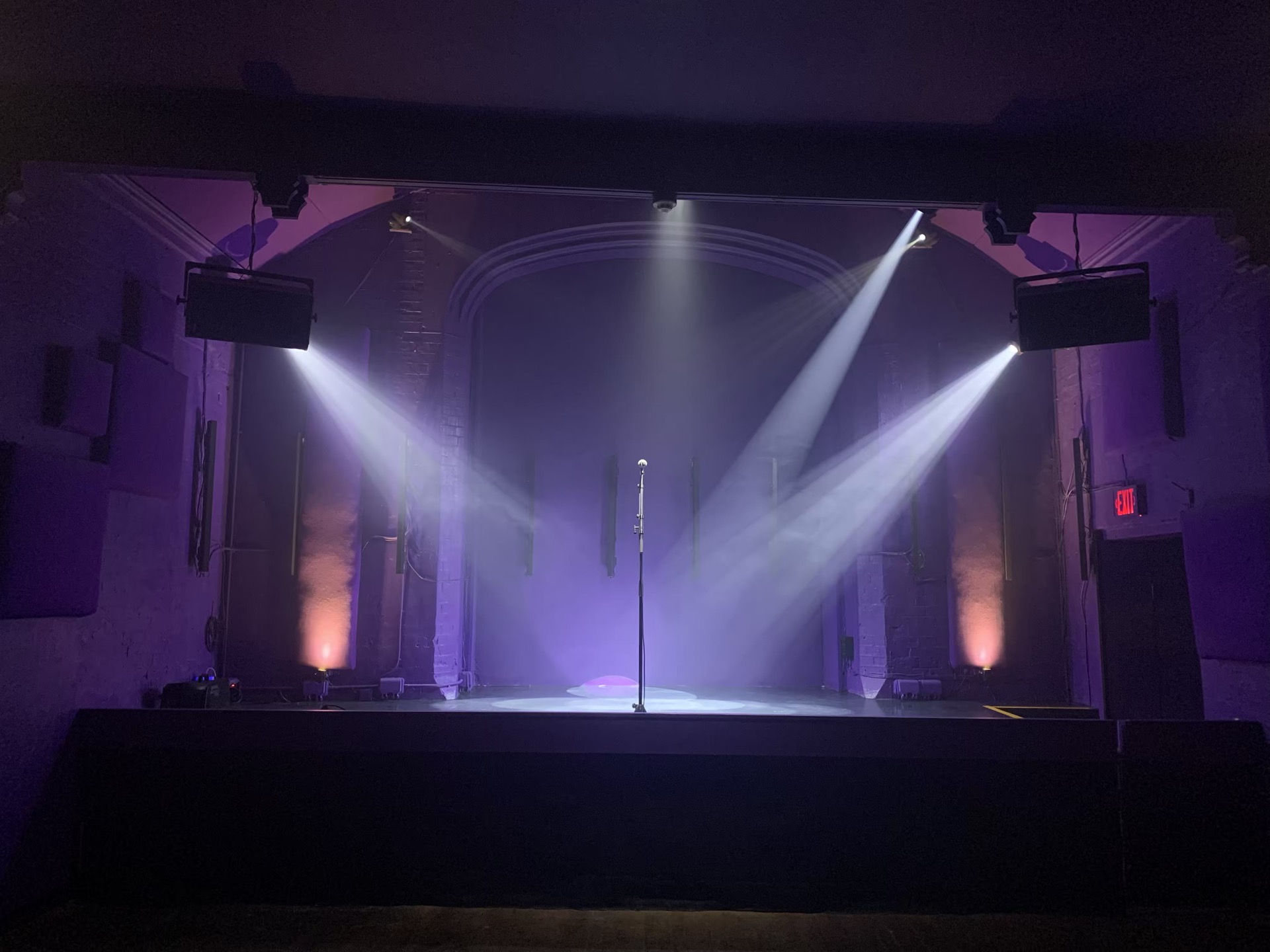 Suspended loudspeakers and lighting over a venue stage