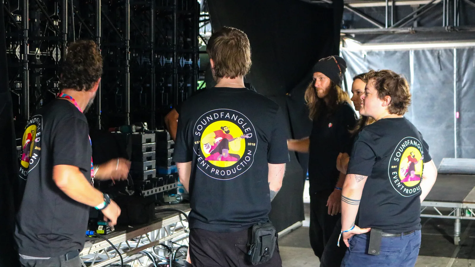 Soundfangled crew coordinating backstage beside stage systems at We Out Here 2026